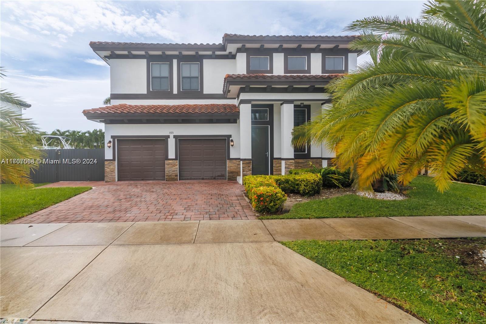 a front view of a house with a yard and a garden