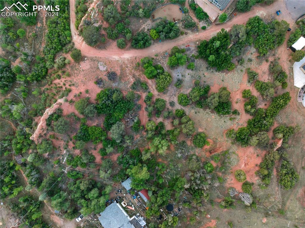 an aerial view of residential house with outdoor space and trees all around