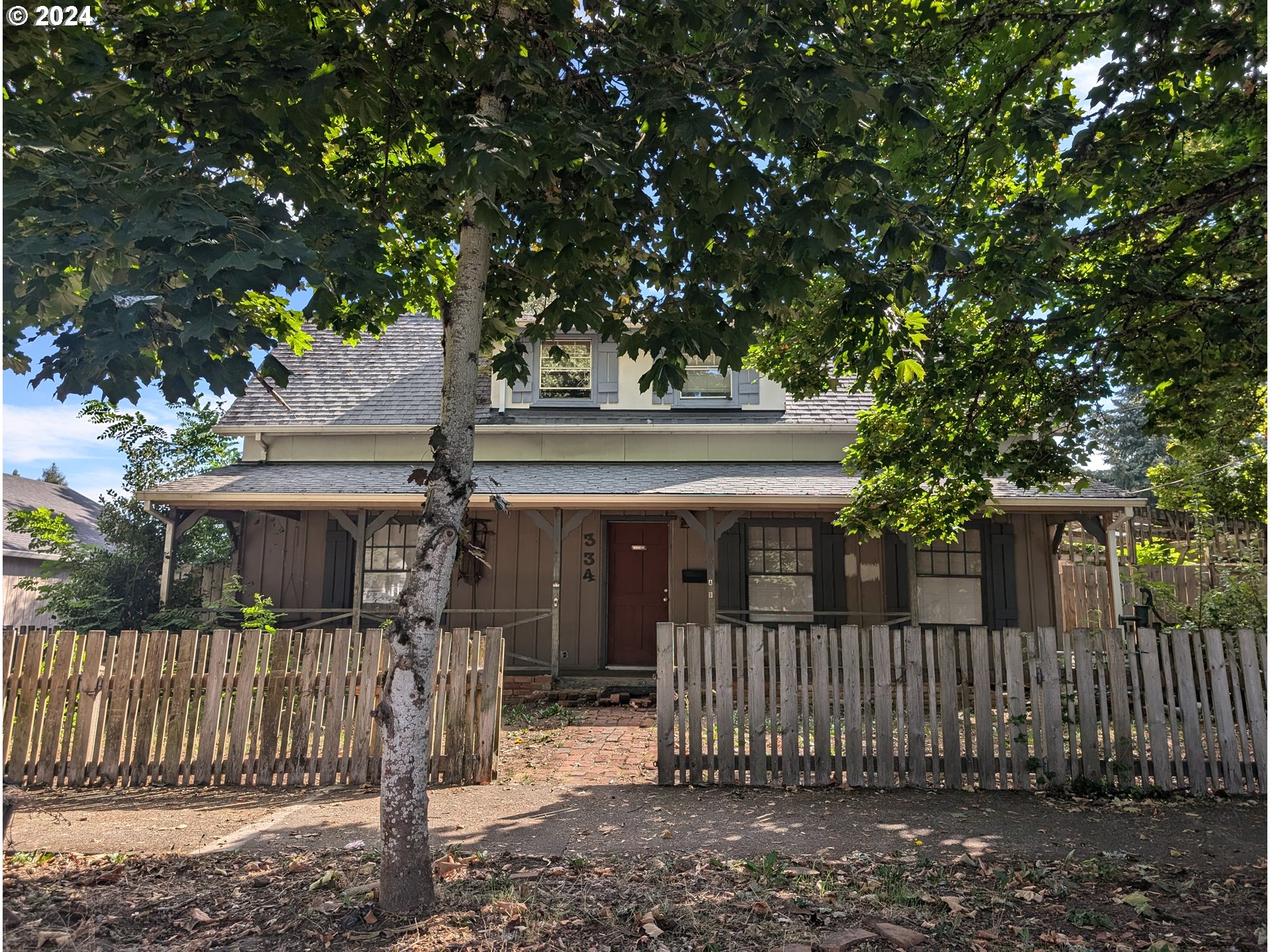 a front view of a house with a tree