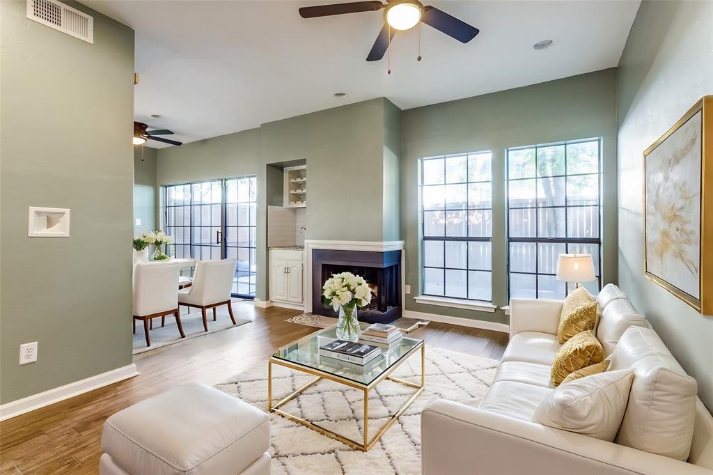 a living room with furniture a fireplace and a floor to ceiling window