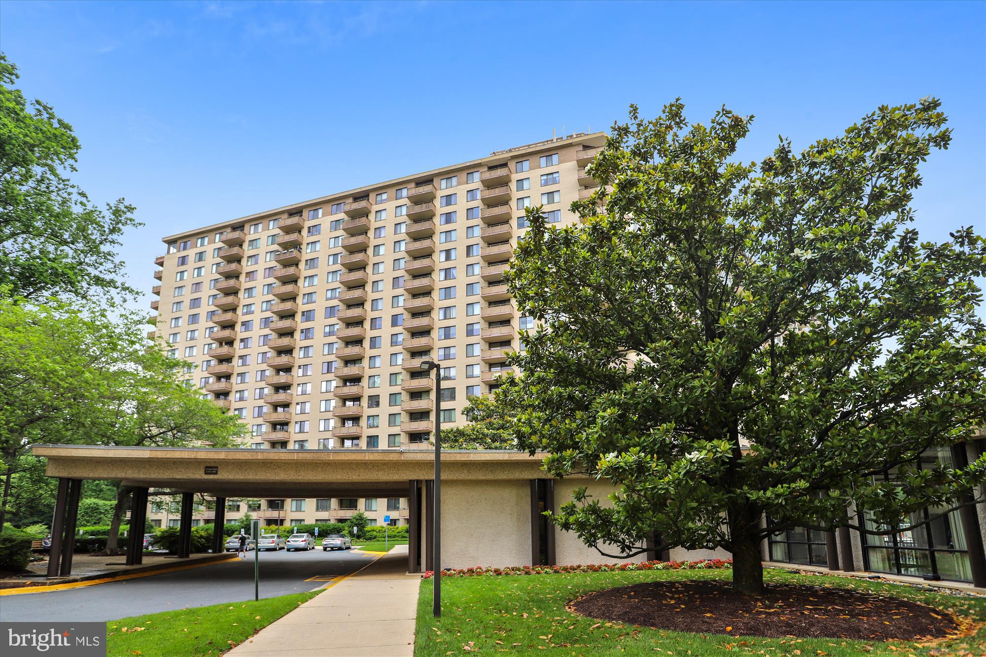 a view of a large building with a big yard and large trees