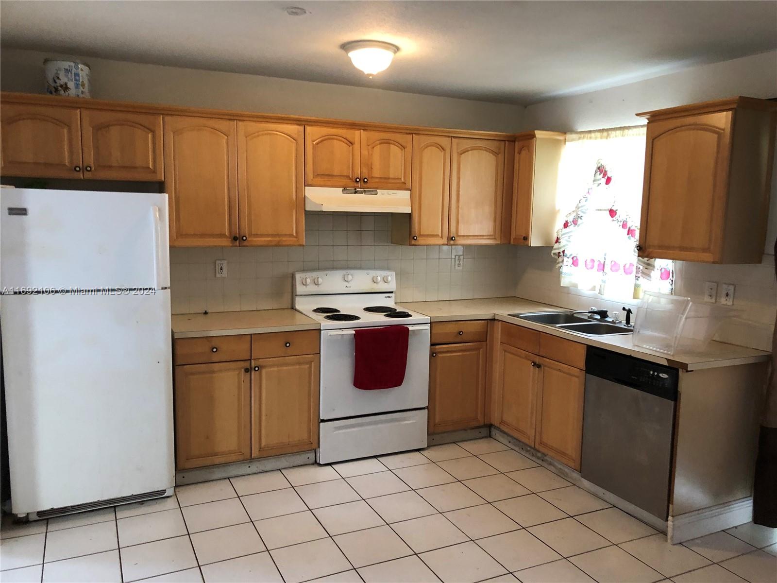 a kitchen with a stove sink and cabinets