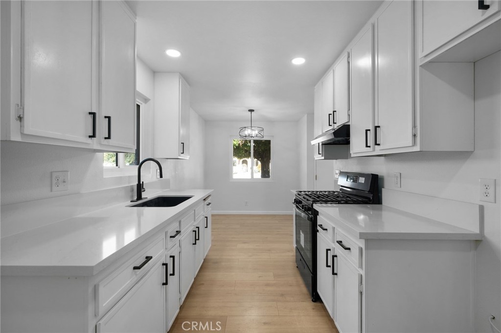 a kitchen with granite countertop white cabinets and stainless steel appliances