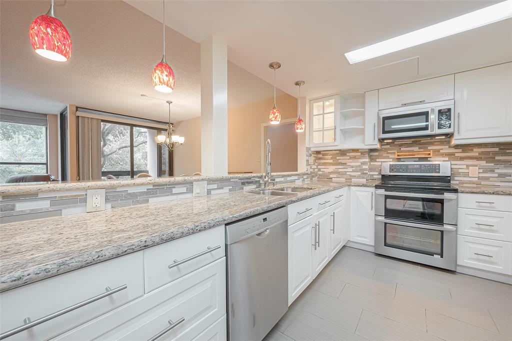 A stylish pendant light hangs over the counter that opens to the breakfast room, perfectly complementing the sleek stainless steel appliances in the kitchen.