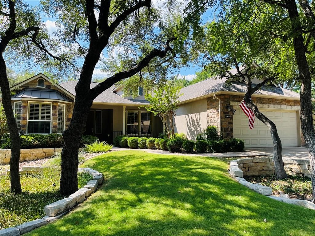 a front view of a house with a yard and an tree