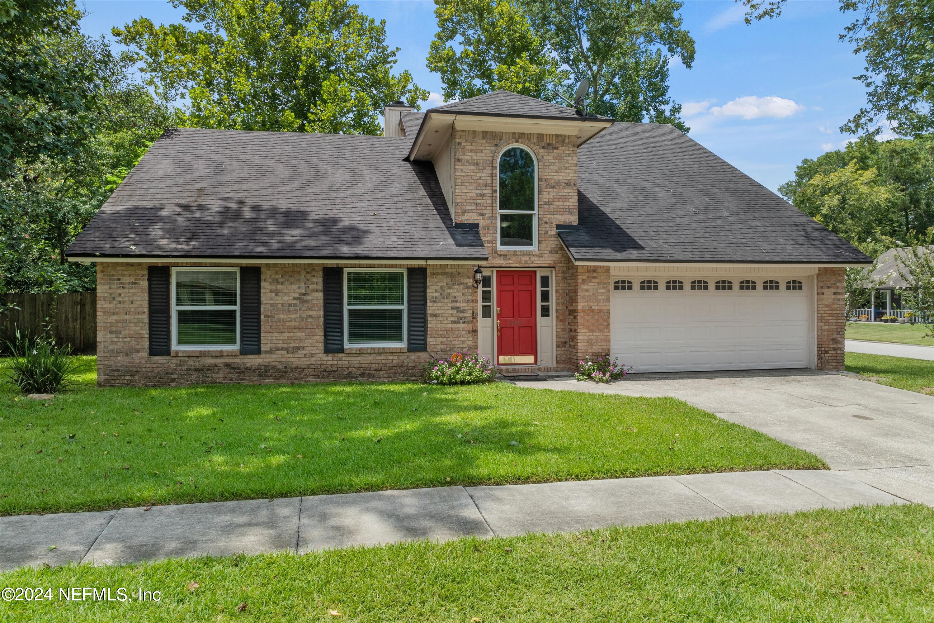 a front view of a house with a garden and yard