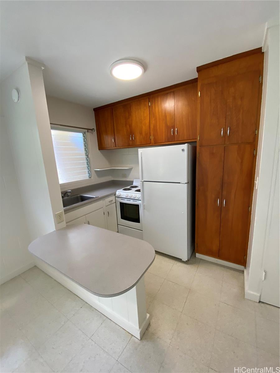 a kitchen with a refrigerator sink and cabinets