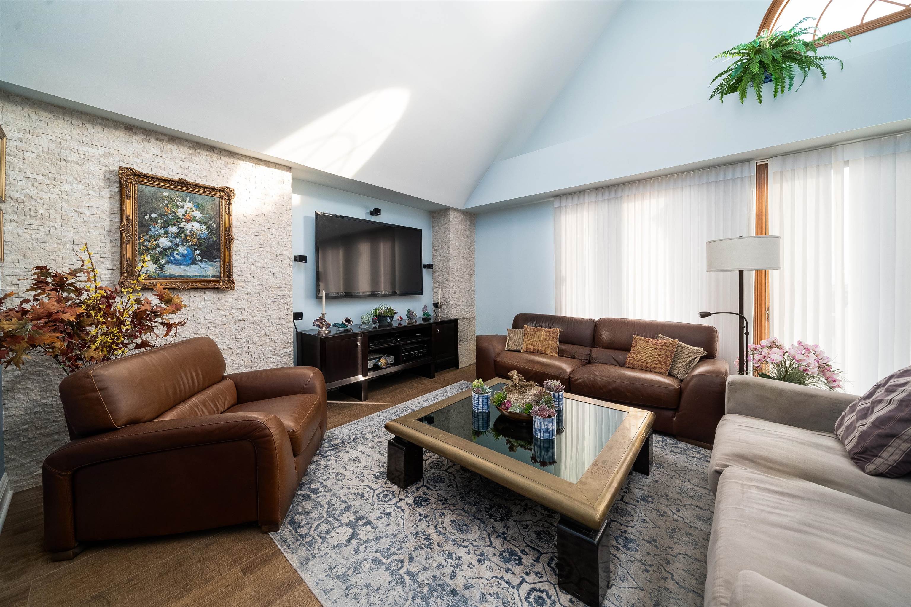 a living room with furniture a rug a window and a flat screen tv