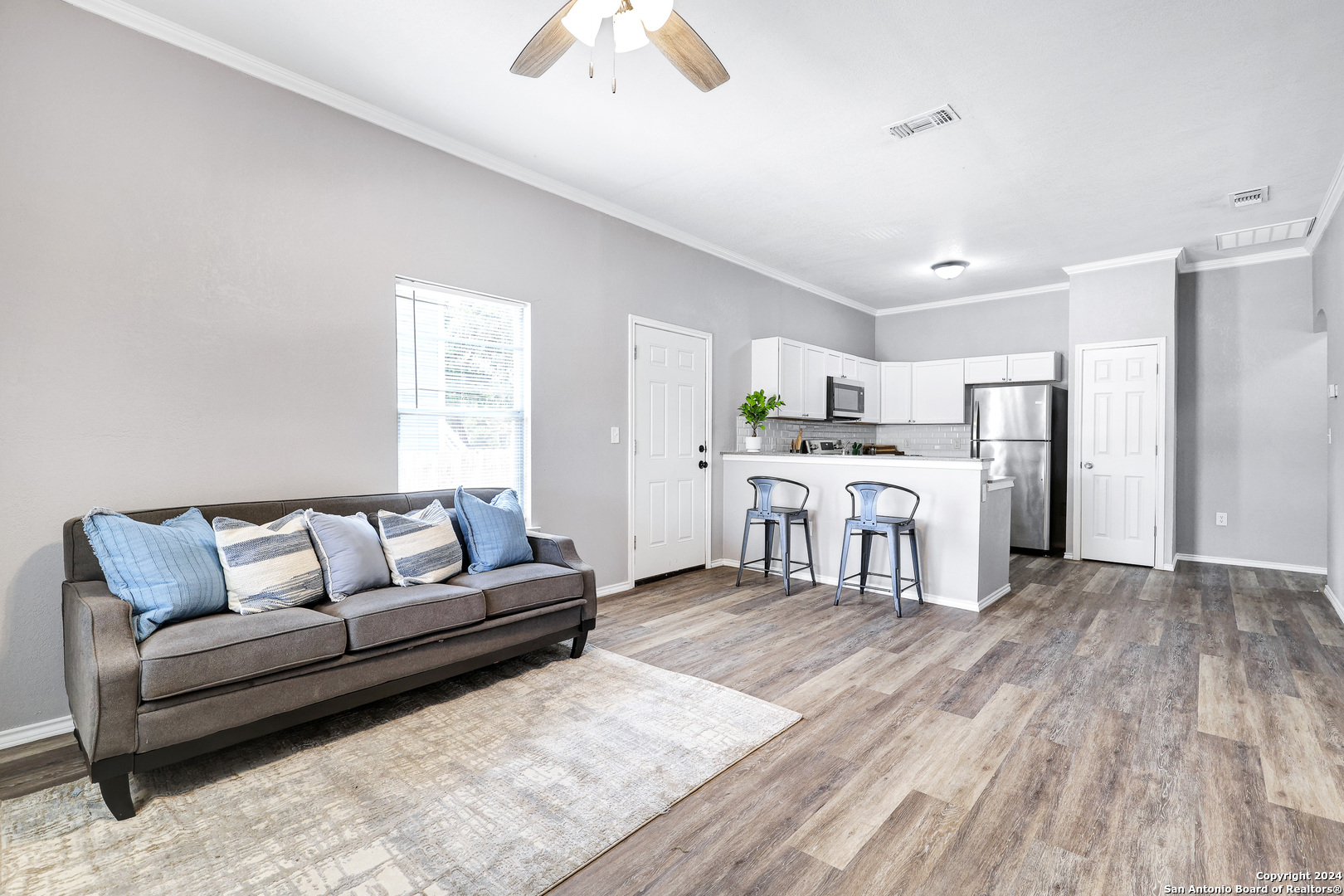 a living room with a couch and a dresser with wooden floor