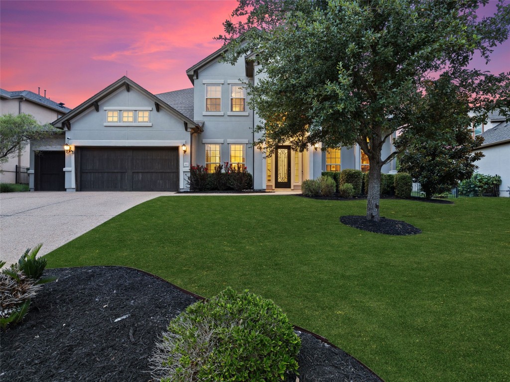 a front view of a house with a yard and trees