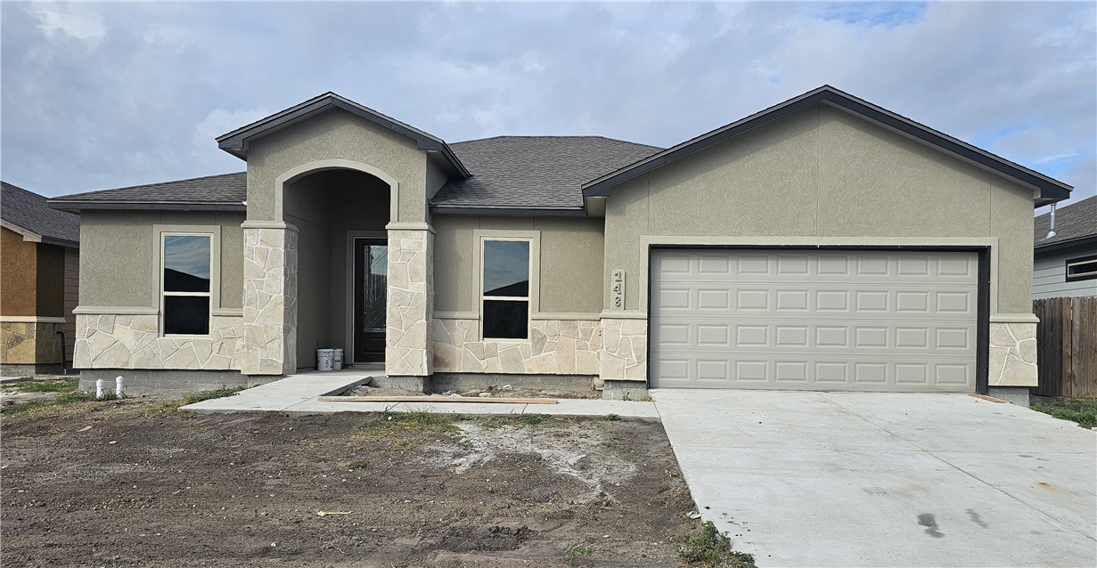 a front view of a house with a yard and garage