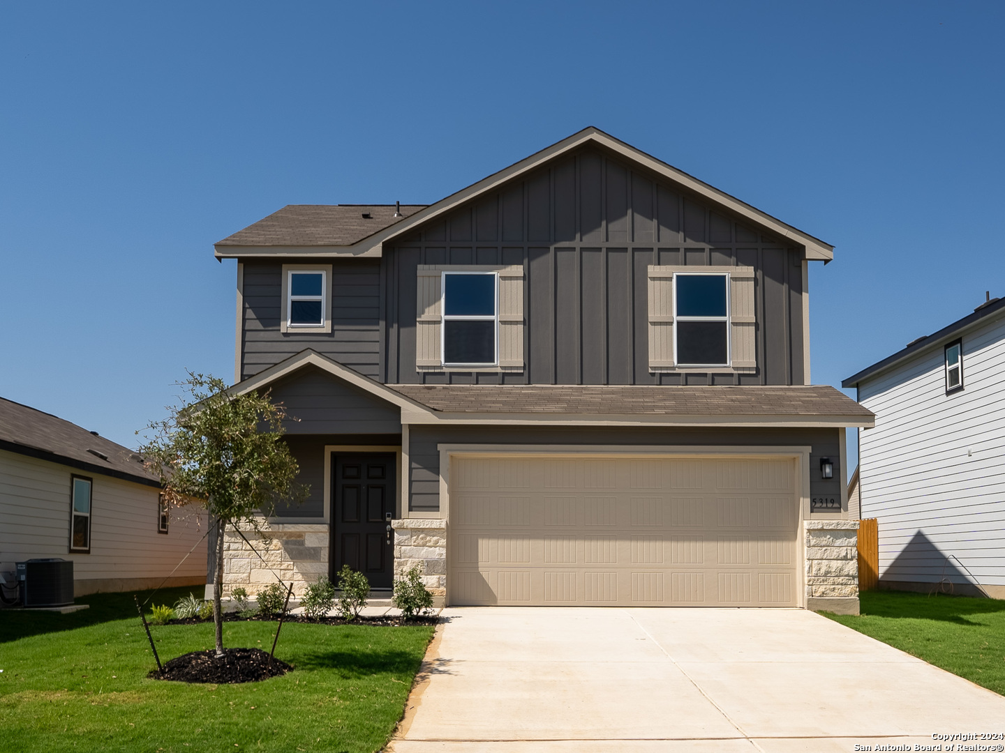 a front view of a house with a yard and garage