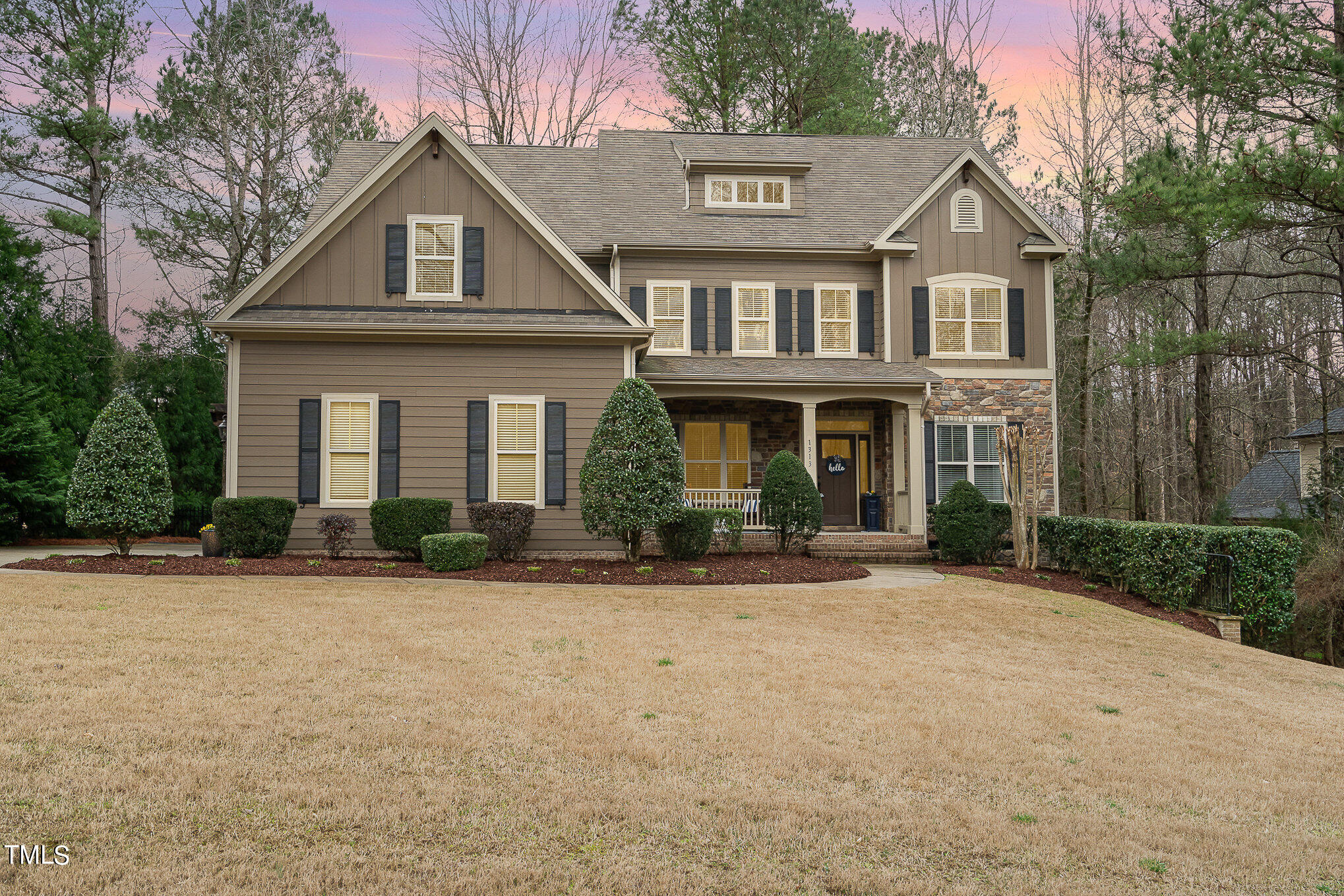 a front view of a house with yard and parking