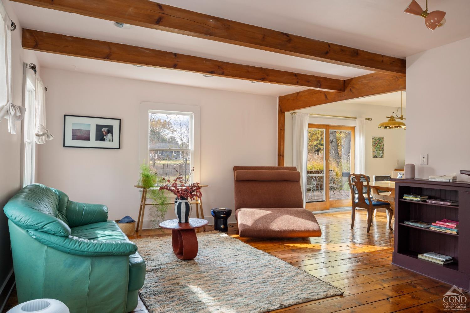 a living room with furniture kitchen view and a window