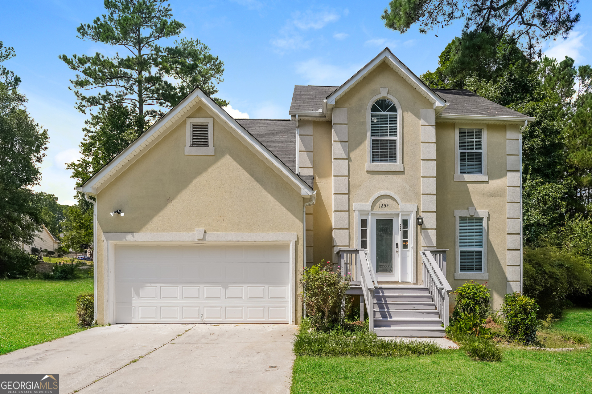 a front view of a house with a yard and trees