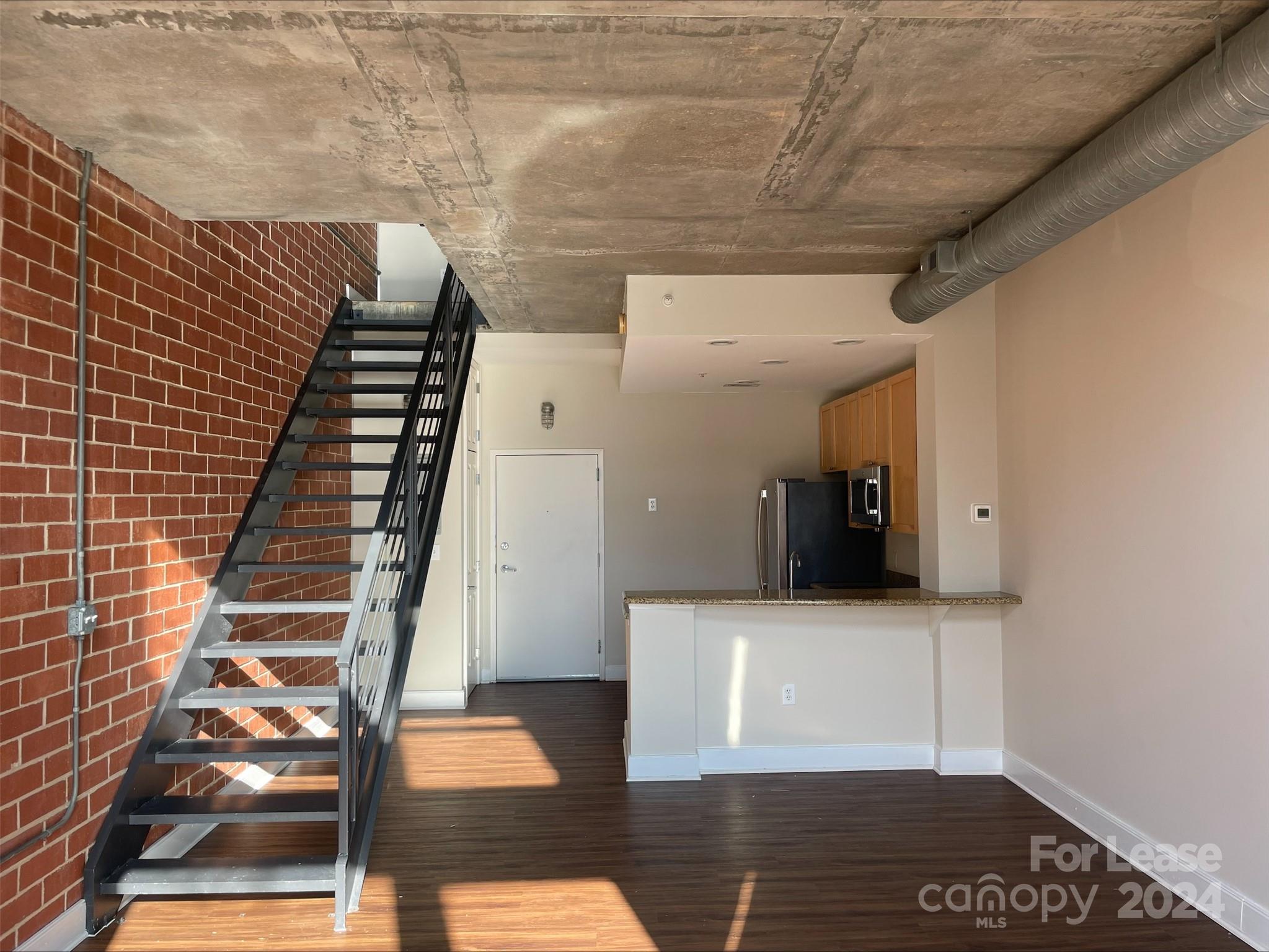 a view of an empty room with wooden floor