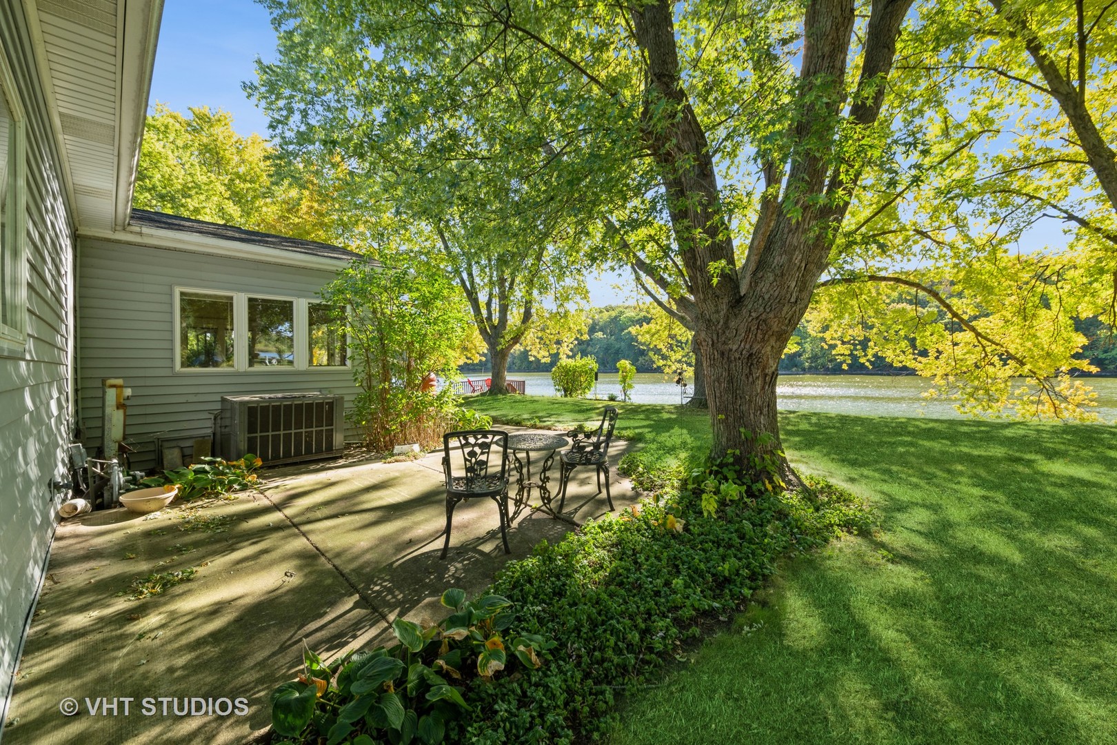 a view of a backyard with table and chairs and a large tree