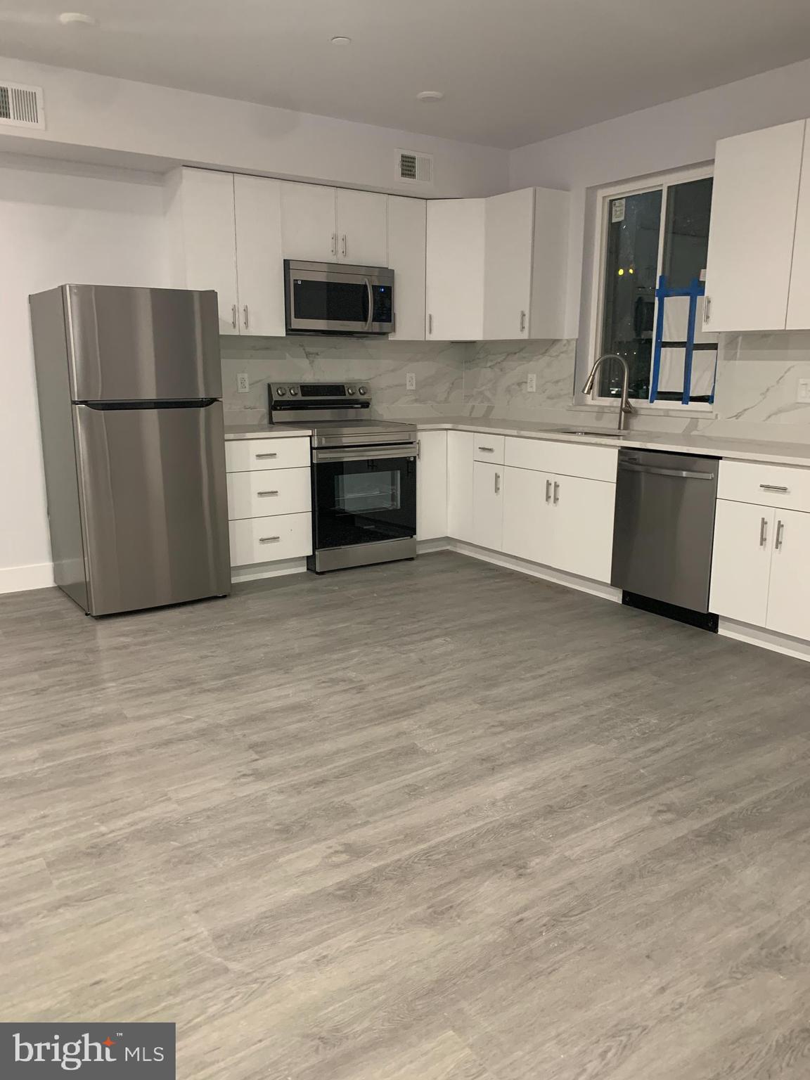 a kitchen with stainless steel appliances a refrigerator sink and microwave