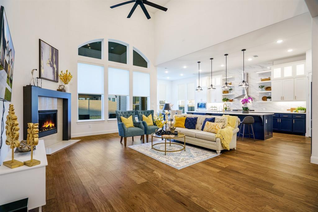 a living room with fireplace furniture and a kitchen view