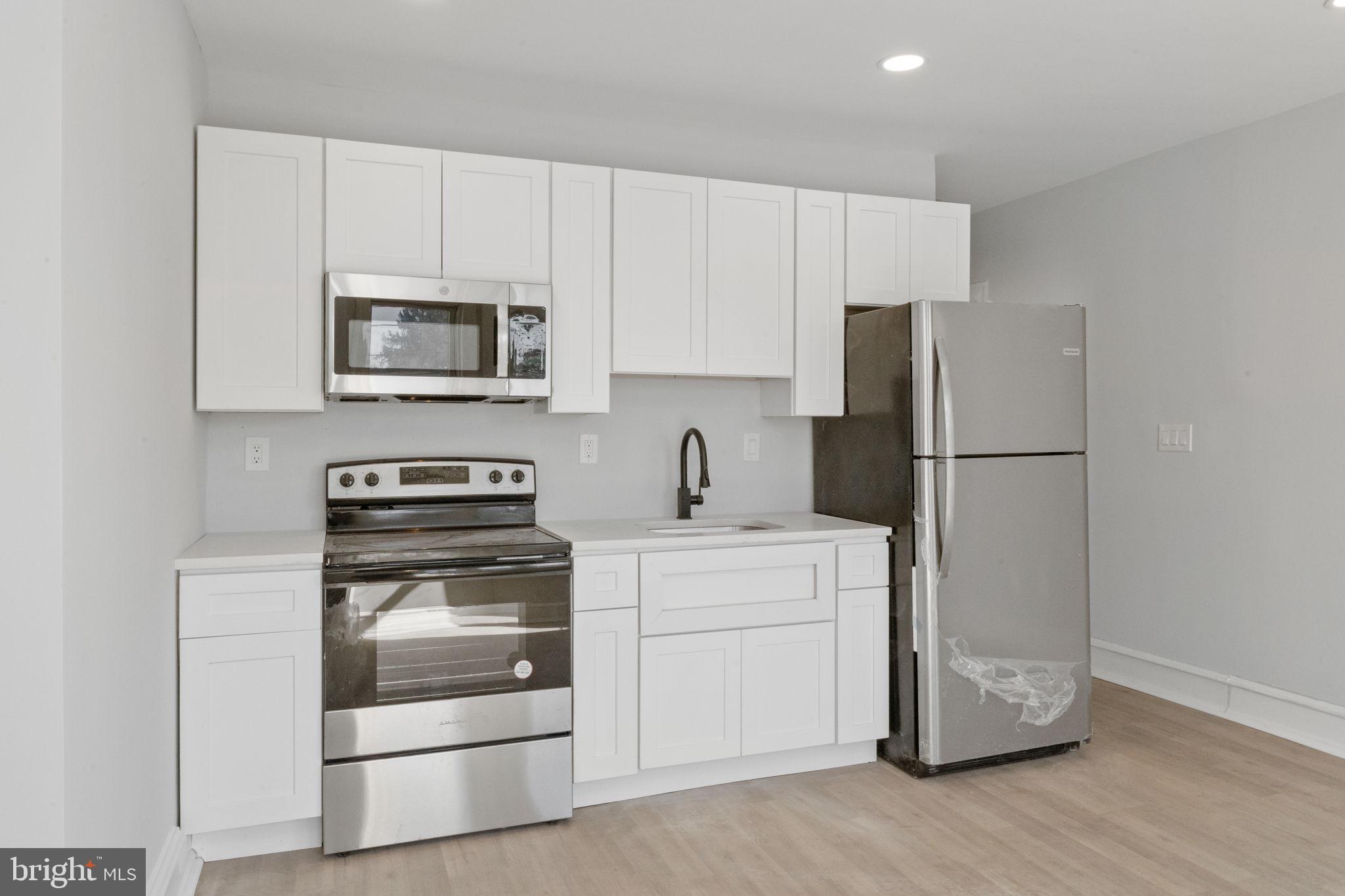 a kitchen with cabinets stainless steel appliances and a window