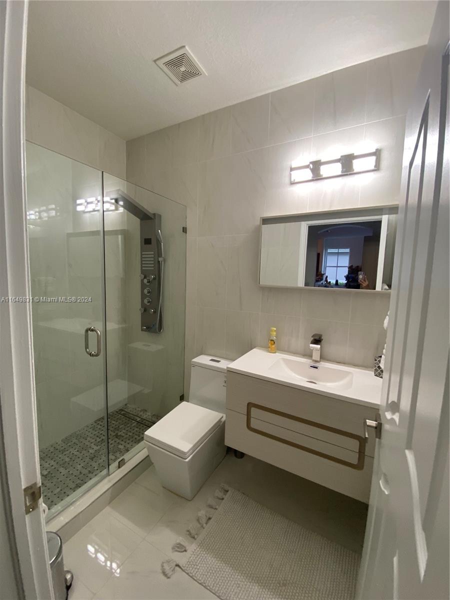 a bathroom with a sink mirror and toilet