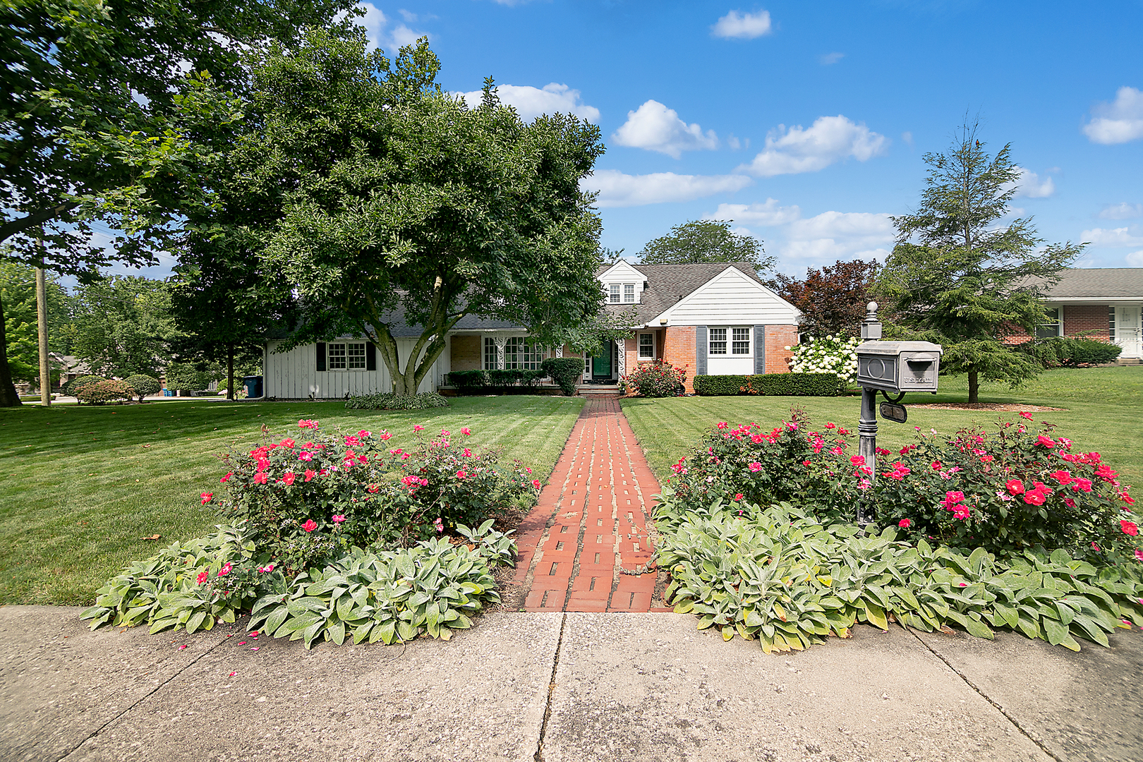 a front view of a house with a big yard and potted plants