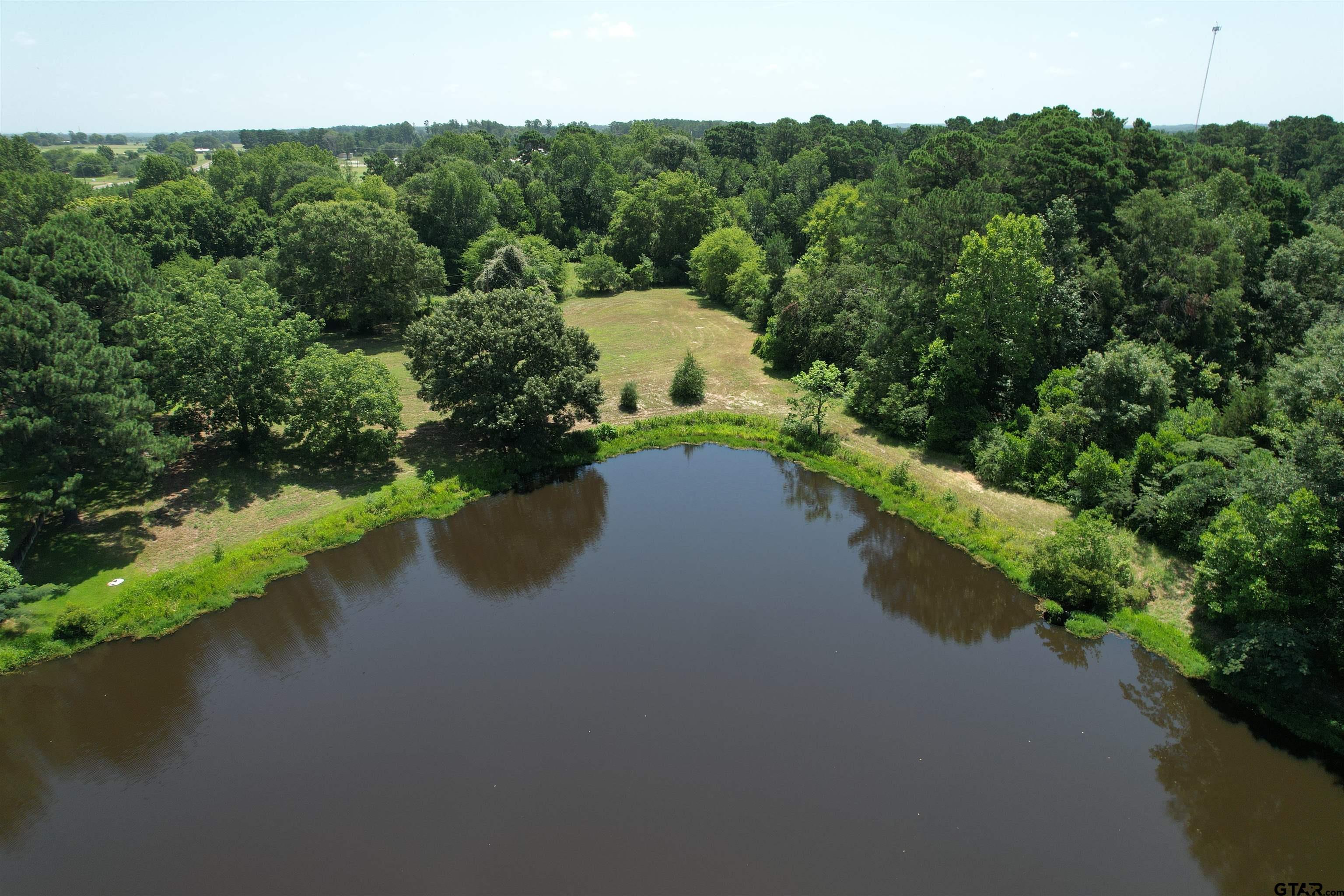 an aerial view of a house with a yard and lake view