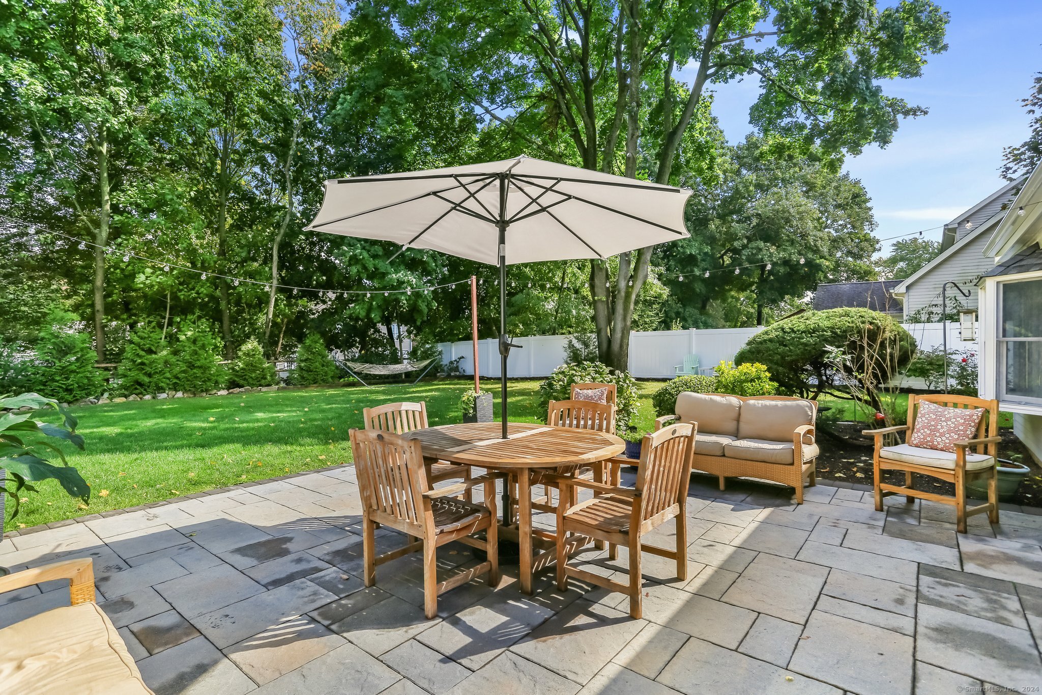 a view of a backyard with furniture and a garden