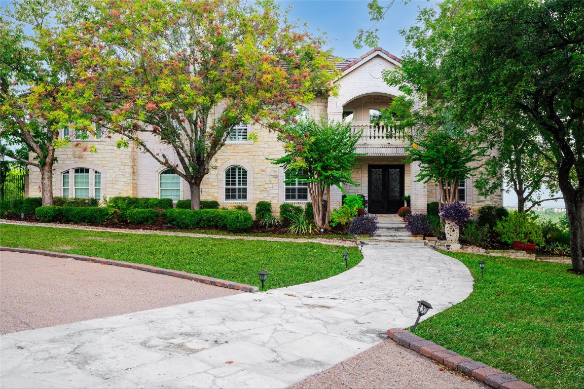 a front view of a house with a yard and trees