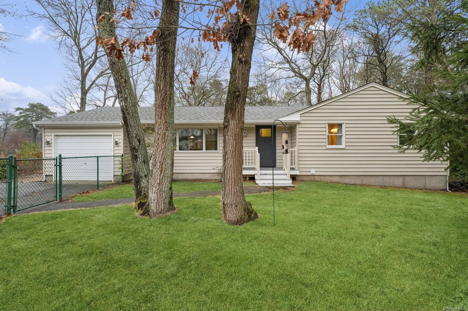 Ranch-style house featuring a garage and a front lawn