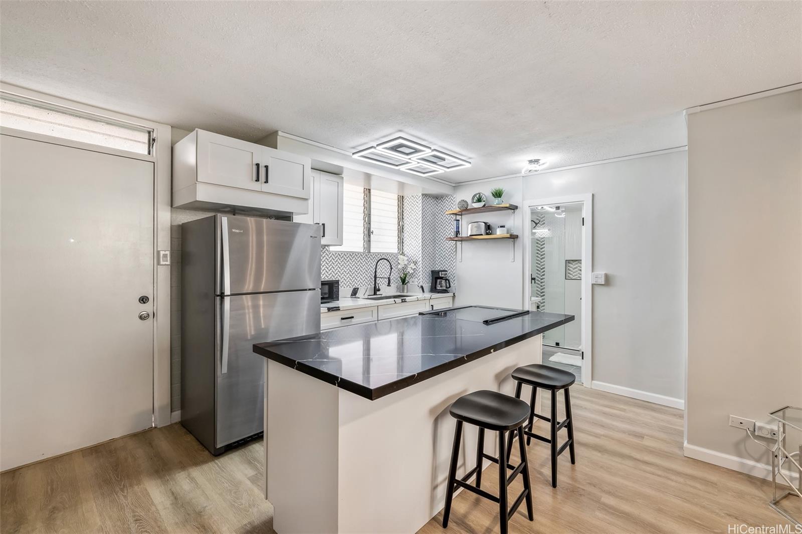 a kitchen with stainless steel appliances a refrigerator and a wooden floor