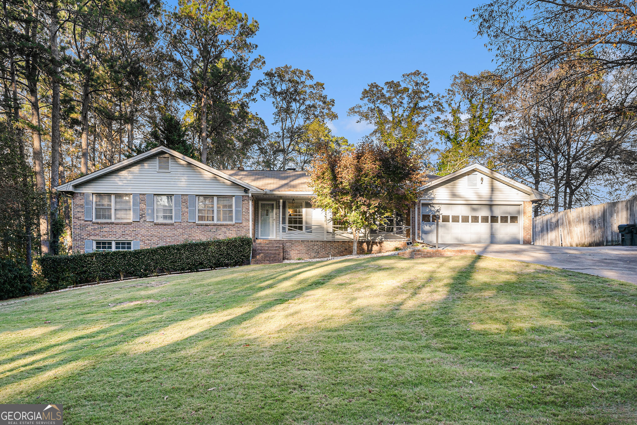 a view of a house next to a big yard with large trees