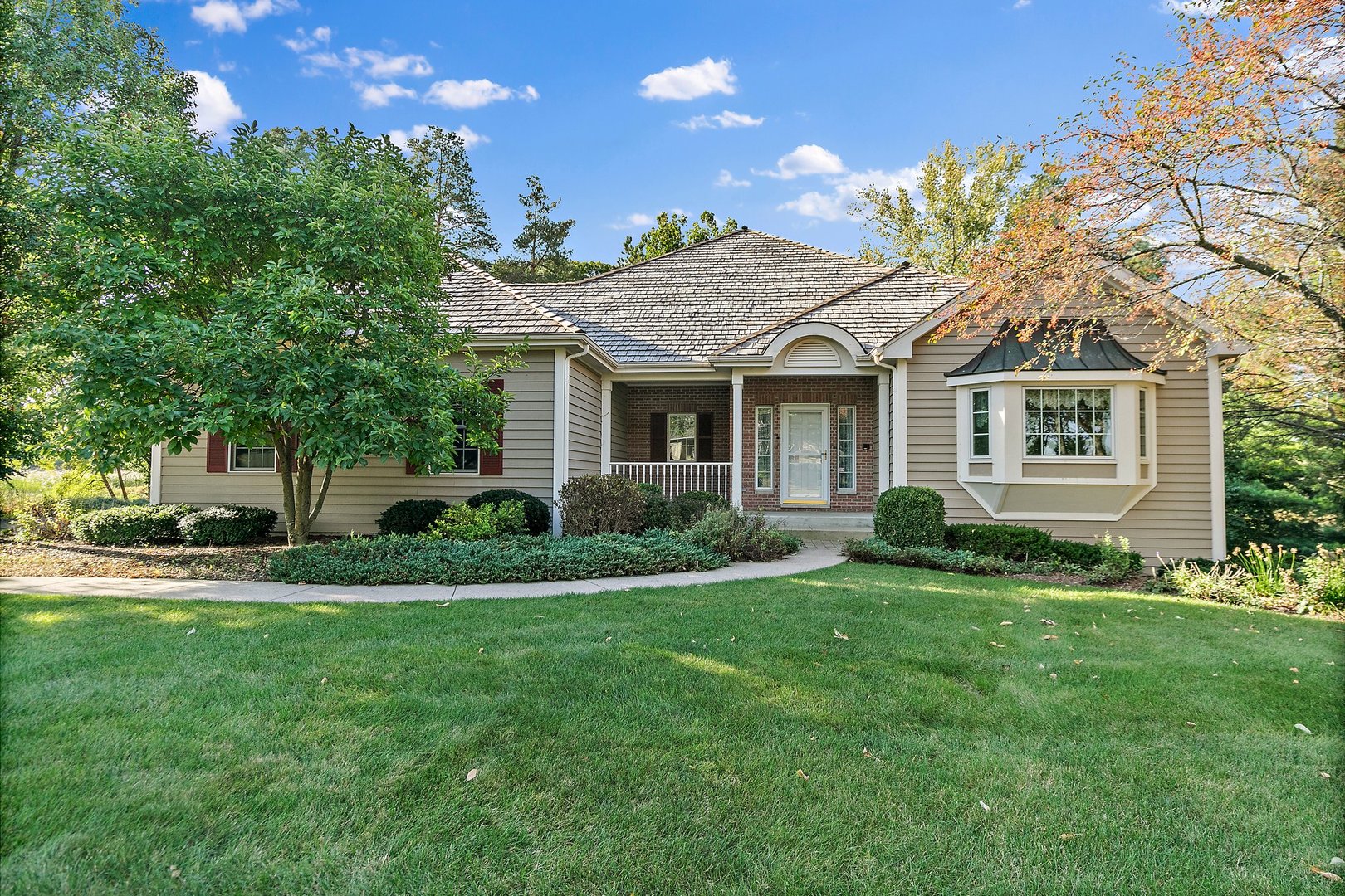 a view of a house with a big yard and large trees