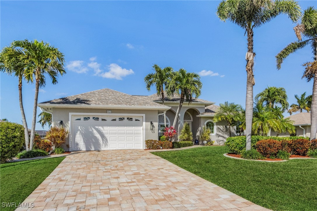 a front view of a house with a garden and palm trees