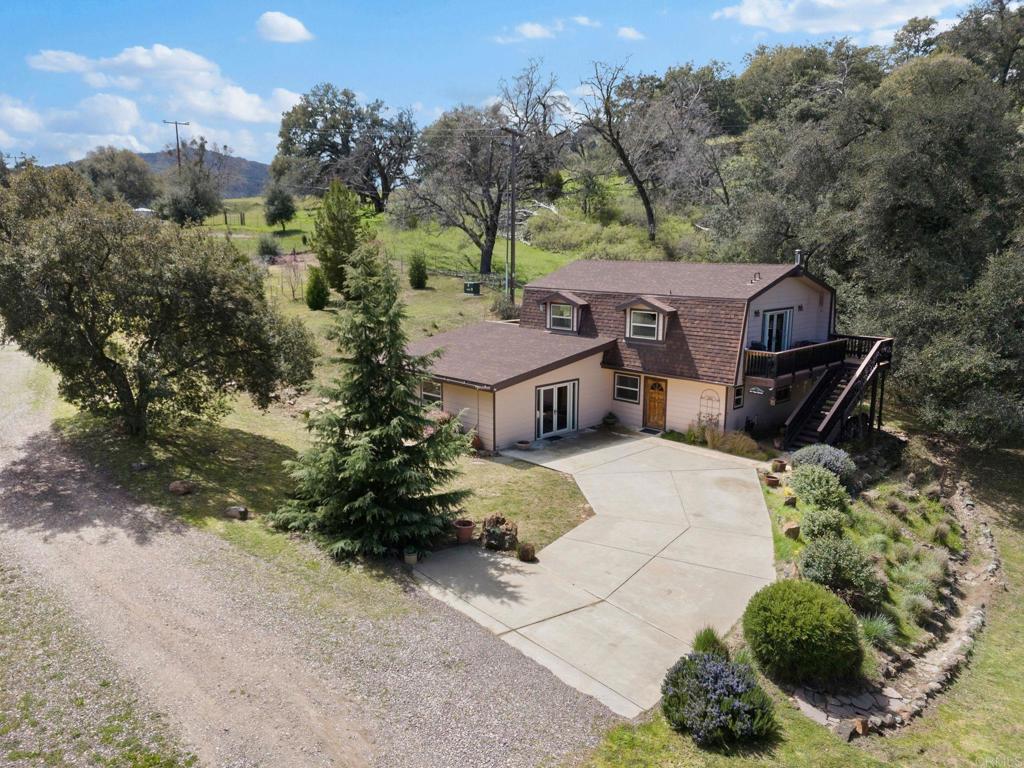 an aerial view of a house with yard and mountain view in back