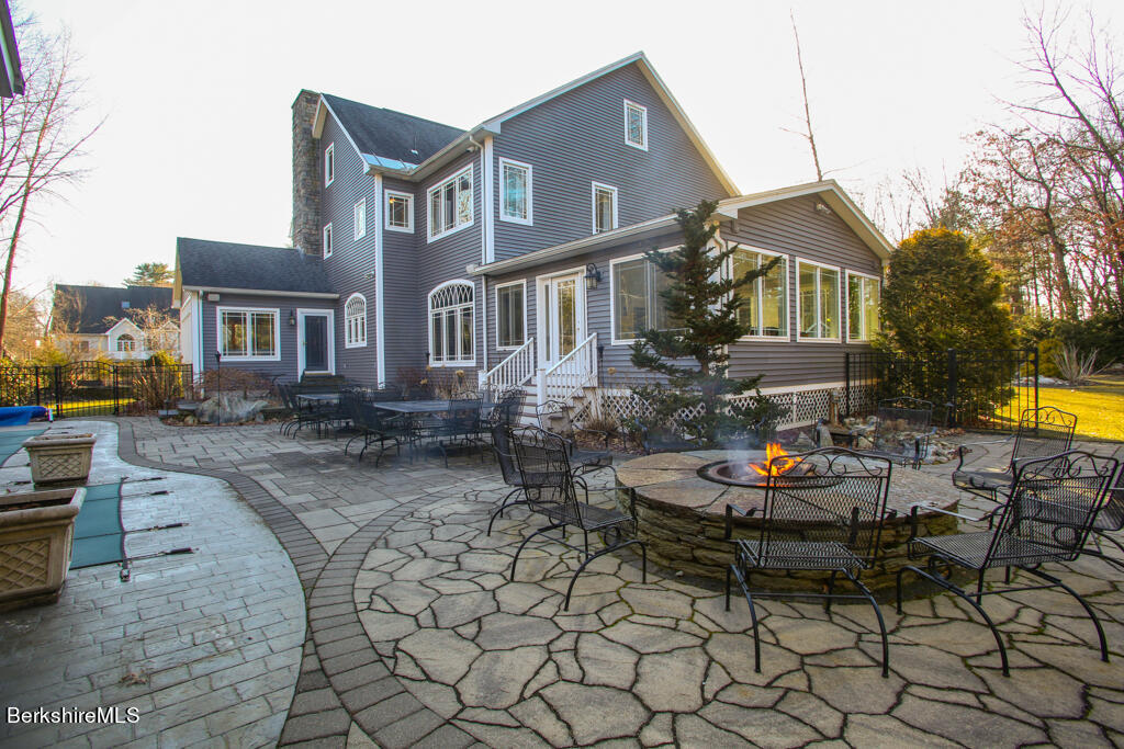 a front view of a house with swimming pool table and chairs