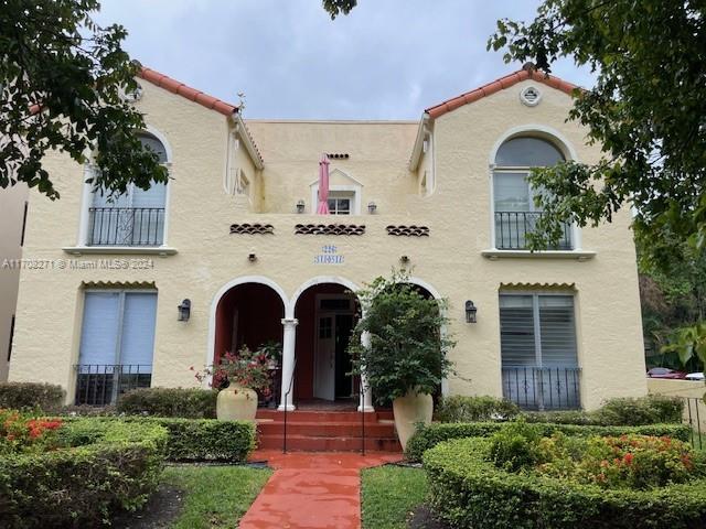 a front view of a house with plants and garden