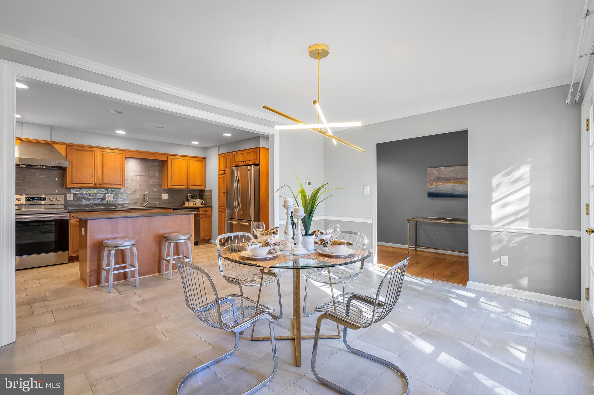 a kitchen with stainless steel appliances kitchen island granite countertop a table and chairs in it