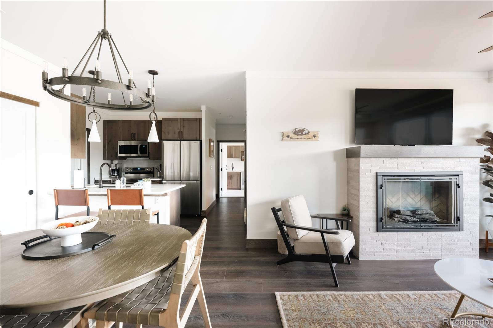 a living room with furniture a flat screen tv and kitchen view