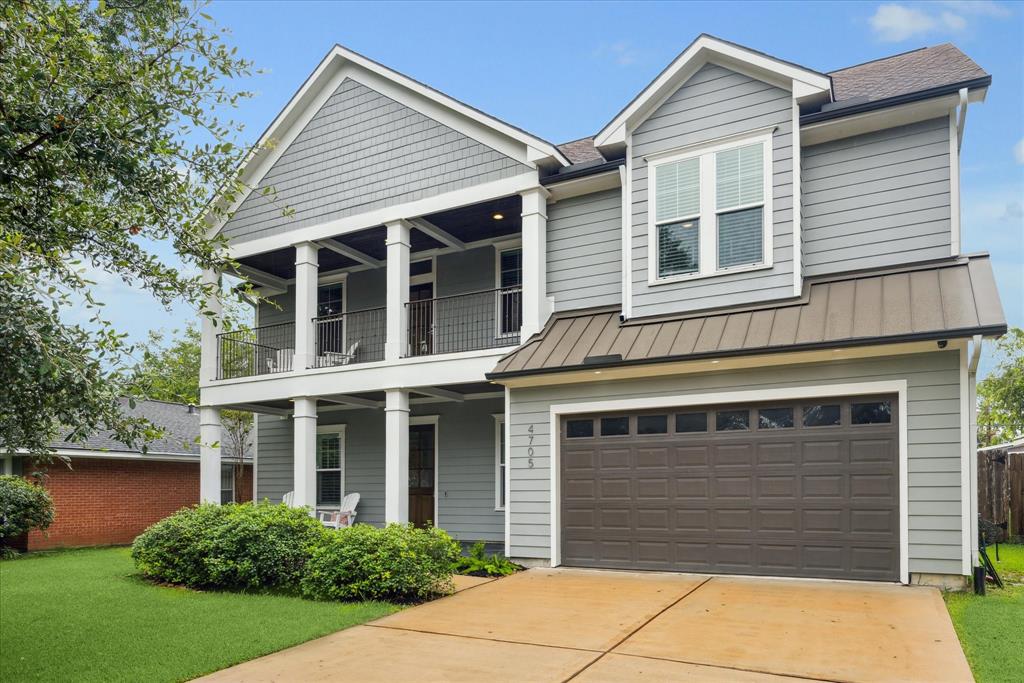 4705 Sanborn Drive is a two-story home featuring a covered front porch, an upper-level balcony, and an attached garage. The curb appeal showcases a well-maintained lawn and landscape.