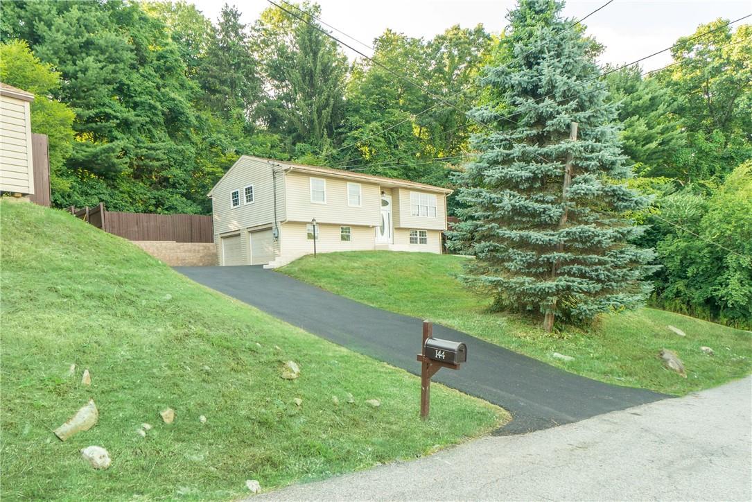 Bi-level home with a garage and a front lawn