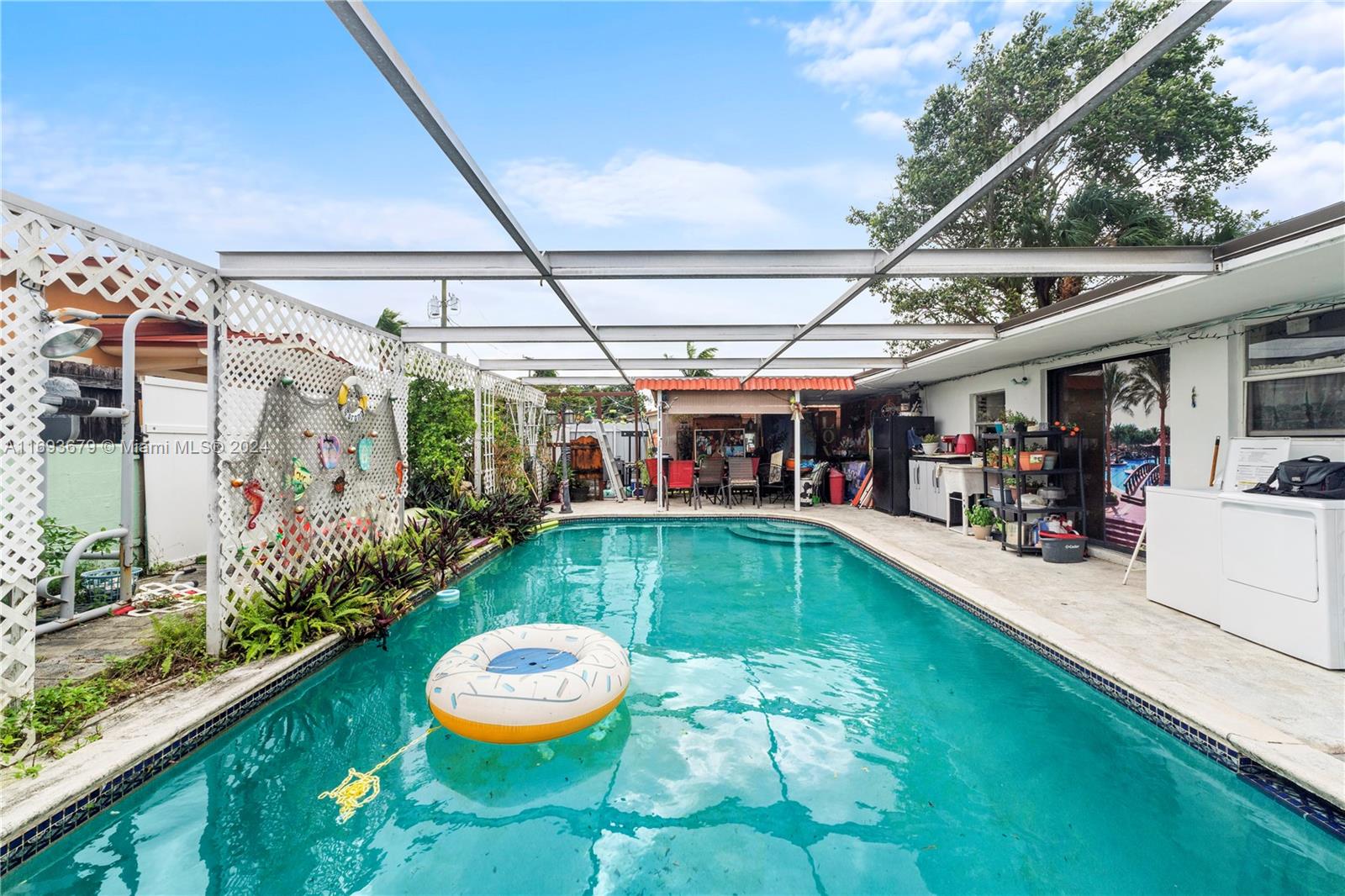 a swimming pool view with a seating space and garden view