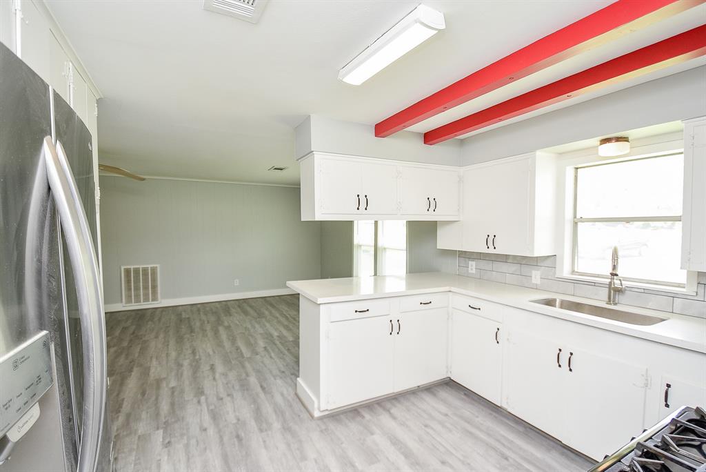 a kitchen with a sink cabinets stainless steel appliances and a window