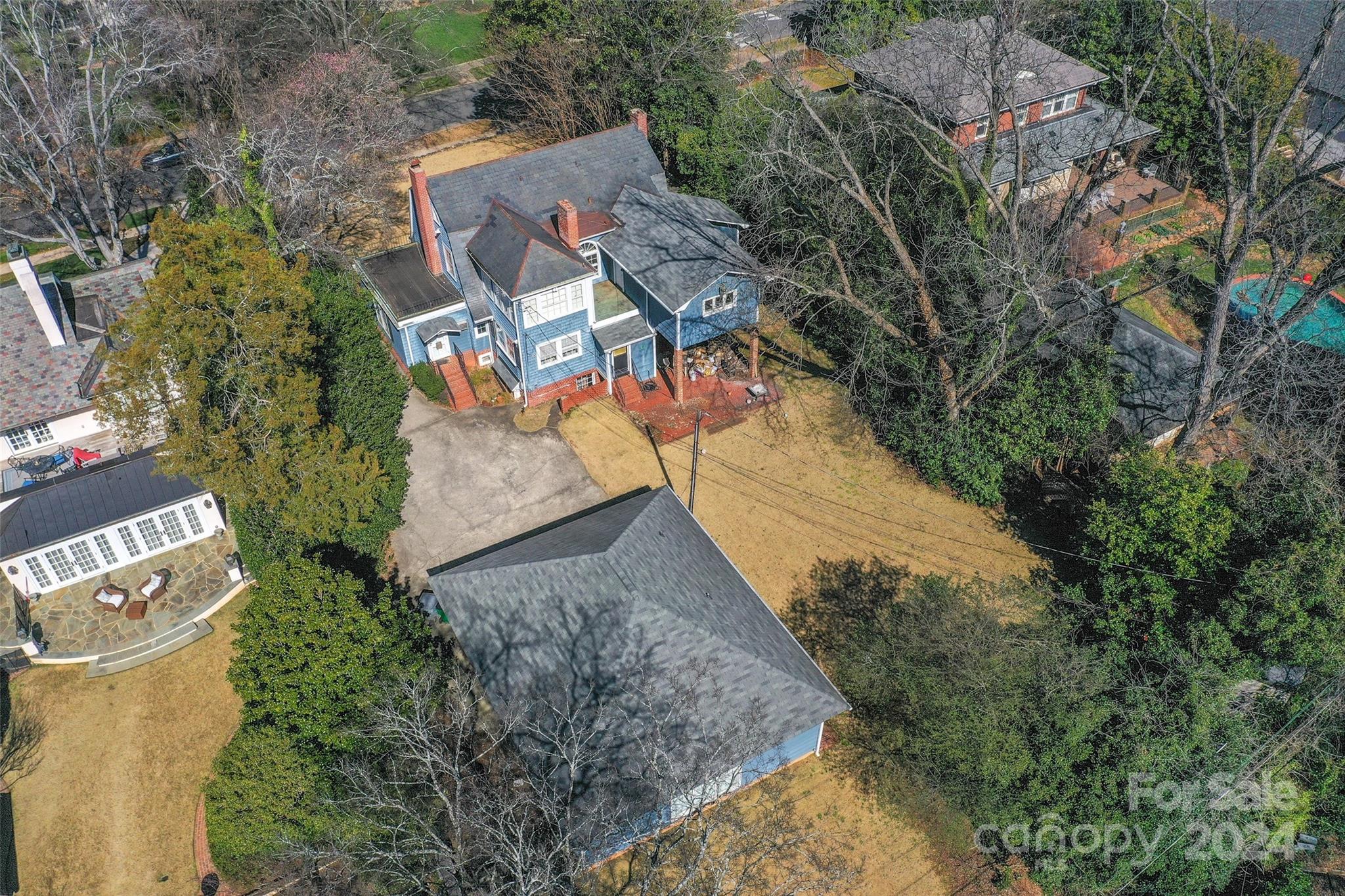 an aerial view of a house with a yard and large trees