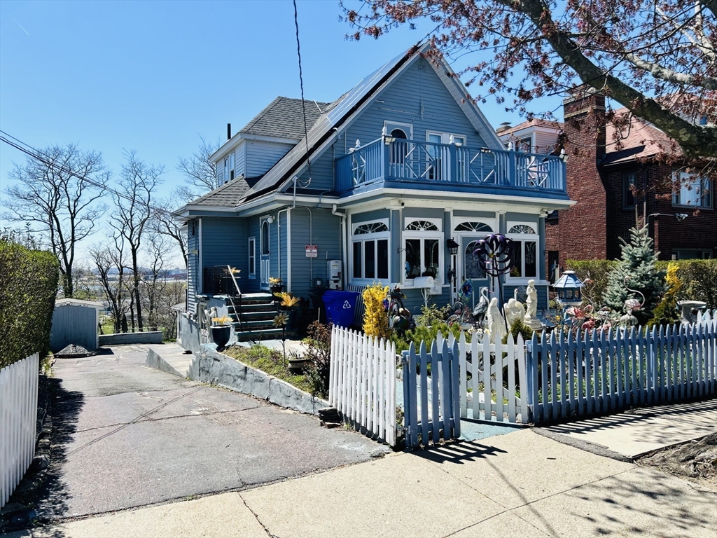 a view of a house with a small yard and wooden fence