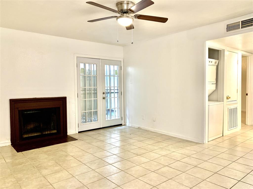 a view of an empty room with a fireplace and a window