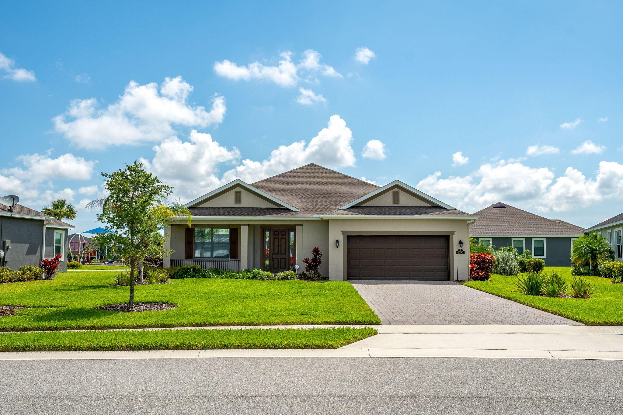 a front view of a house with a garden and trees