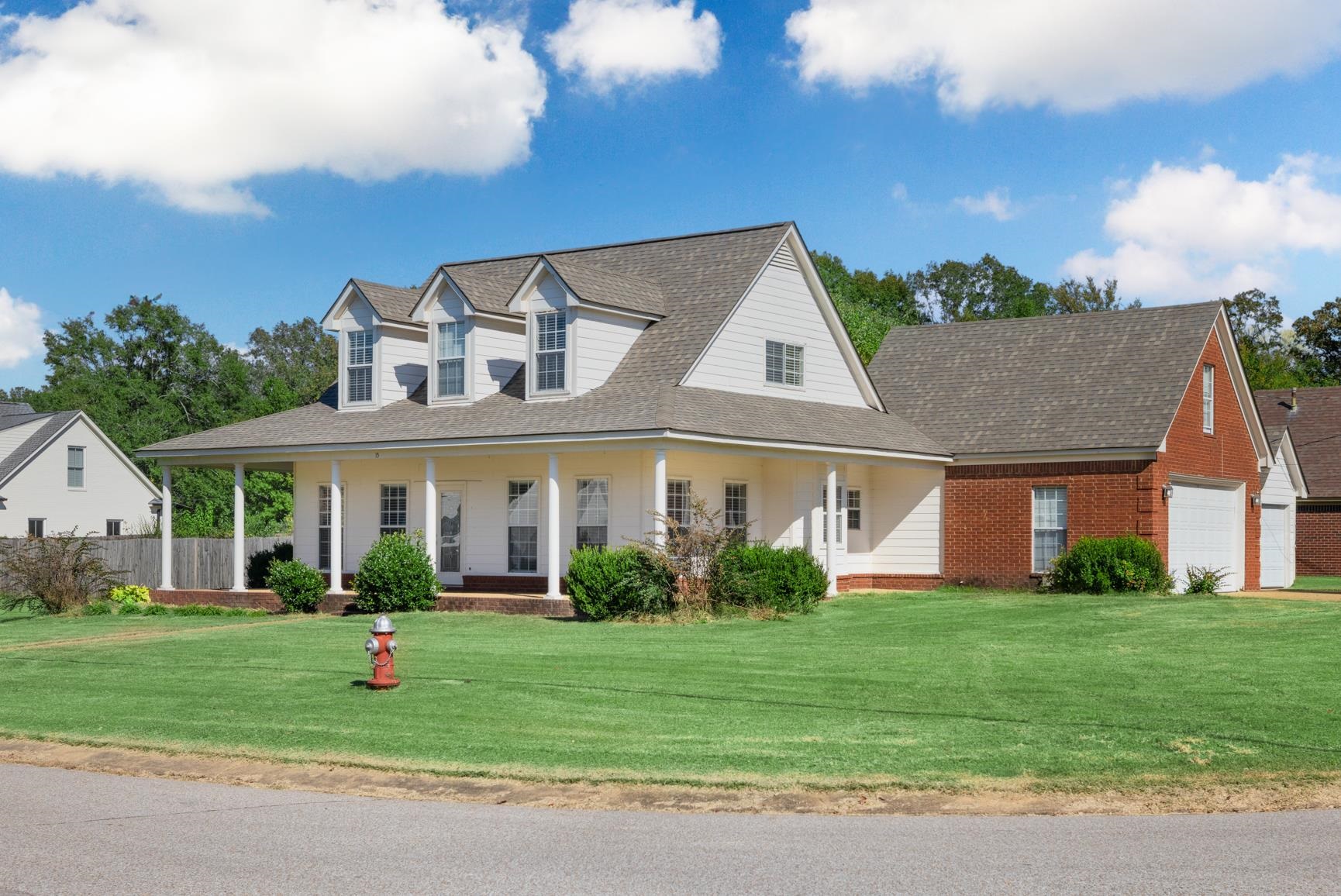 View of front of home featuring a front yard, a garage, and a porch