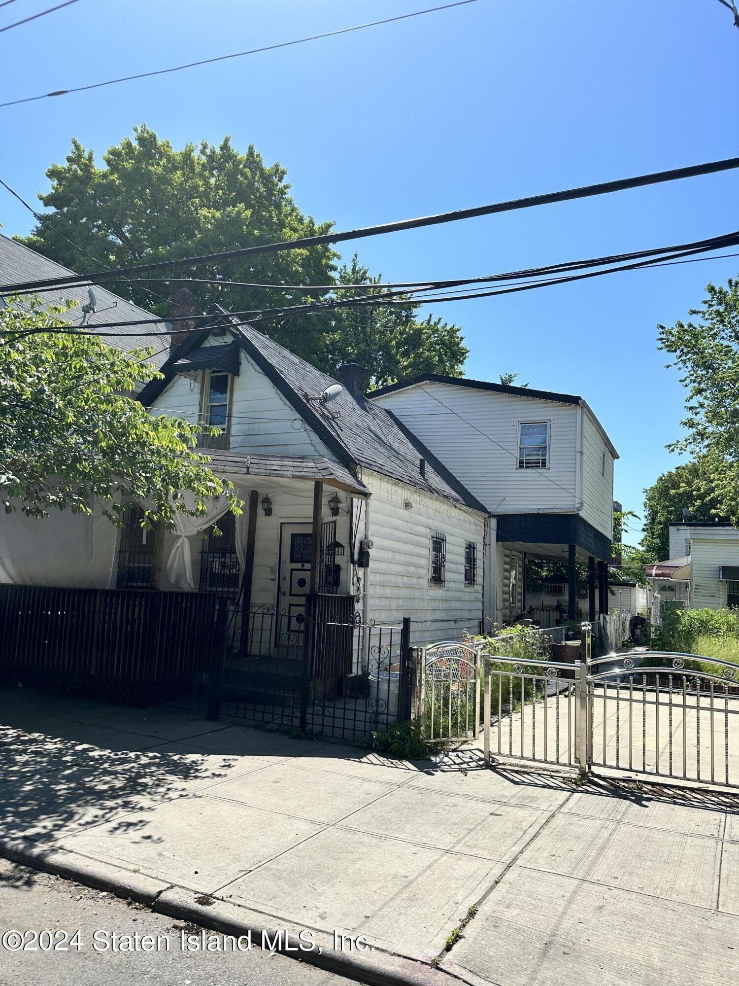 a view of a house with a small yard and wooden fence