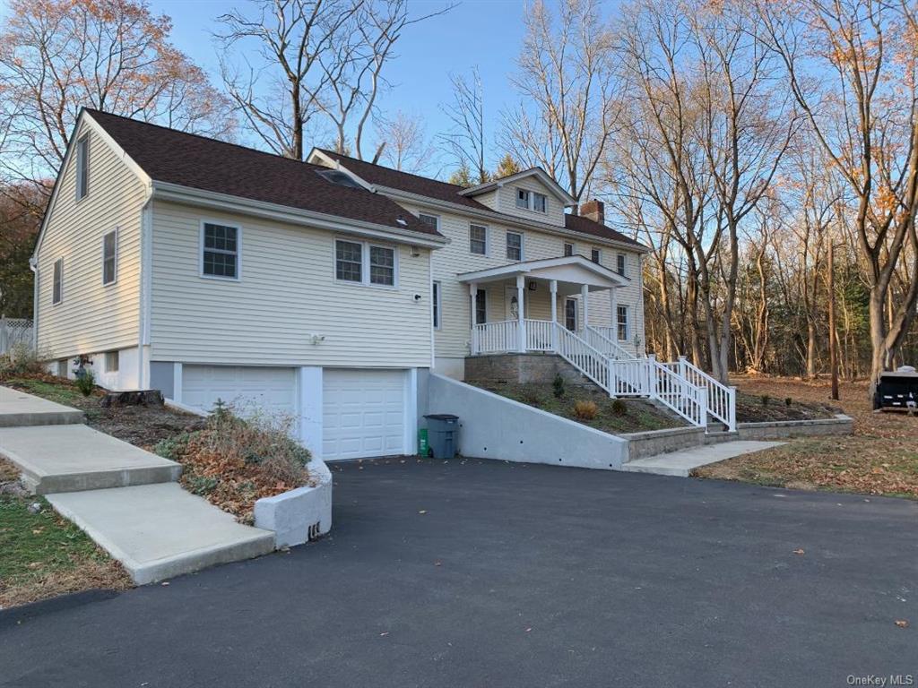 View of property exterior featuring a porch and a two car garage